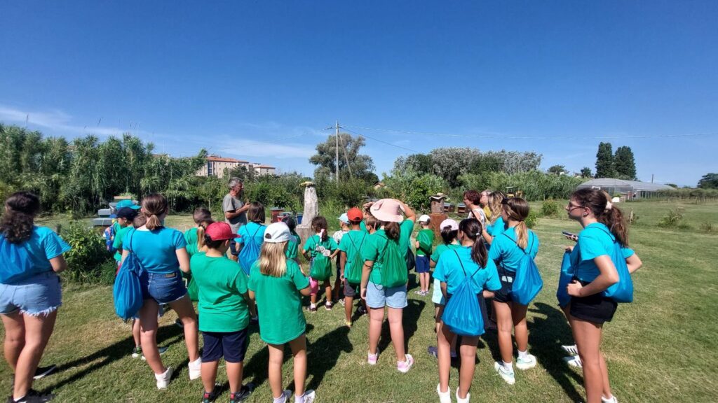 Un gruppo di ragazzi del grest in magliette colorate in mezzo al campo